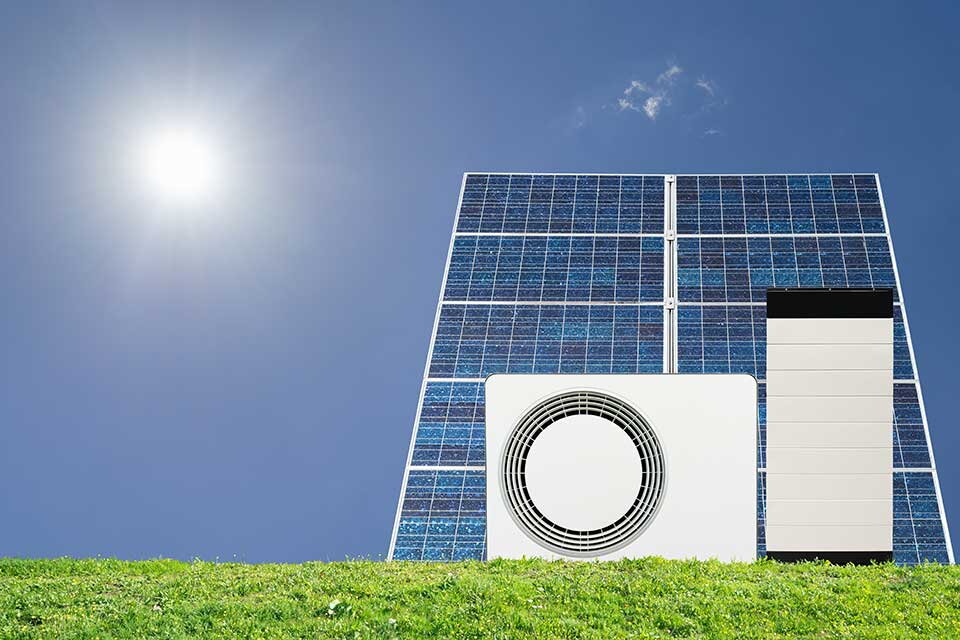 Das Bild zeigt eine Kombination aus Solarpaneelen, Wärmepumpe und Stromspeicher unter klarem Himmel mit Sonnenschein. Es symbolisiert die Nutzung erneuerbarer Energien und energieeffizienter Haustechnik, insbesondere im Zusammenhang mit nachhaltiger Strom