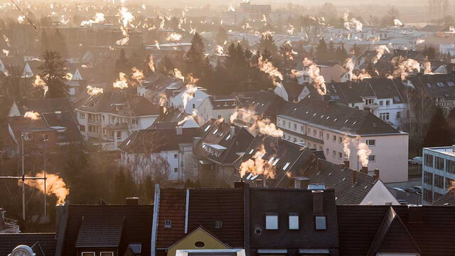 Ausblick auf die Dächer einer Stadt mit rauchenden Schornsteinen